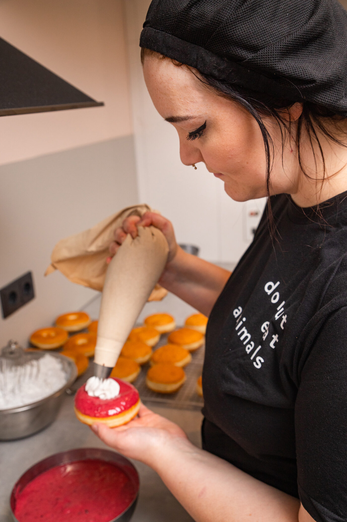 Melanie decorating a donut with a cream whip.